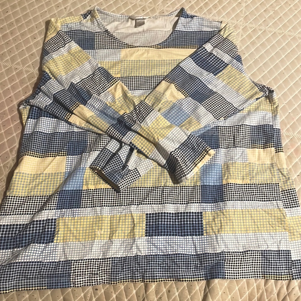 its a long sleeved shirt patterned with yellow, blue black and white dots